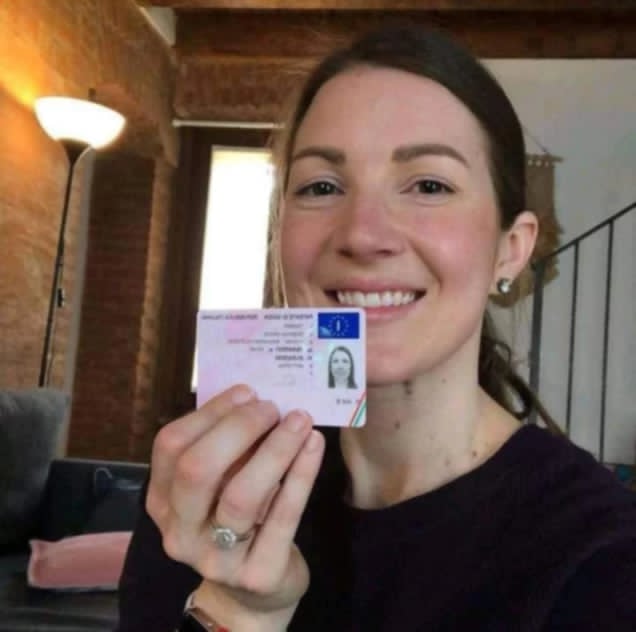 Cliente sorridente mostra la patente italiana appena ottenuta